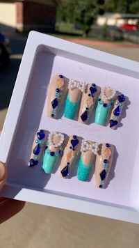 a person is holding a box with blue and white nails